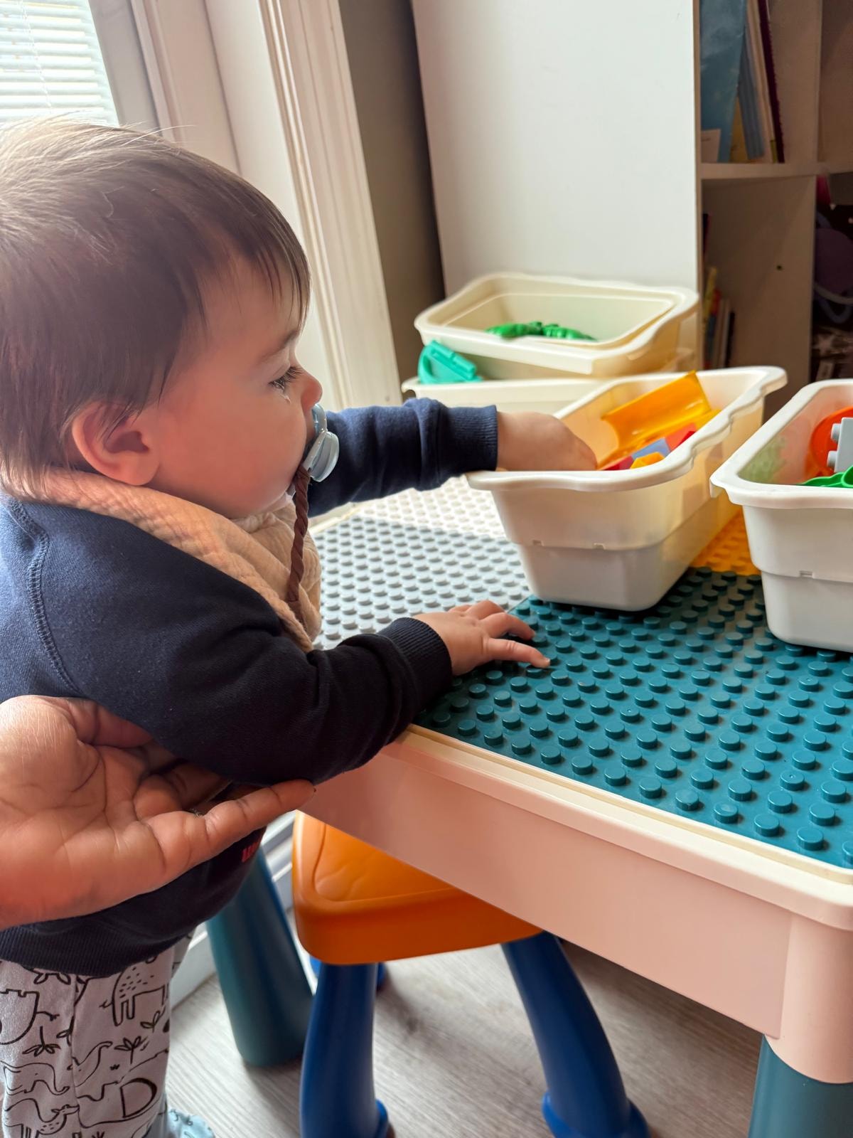 Toddler playing with colorful building blocks on the floor