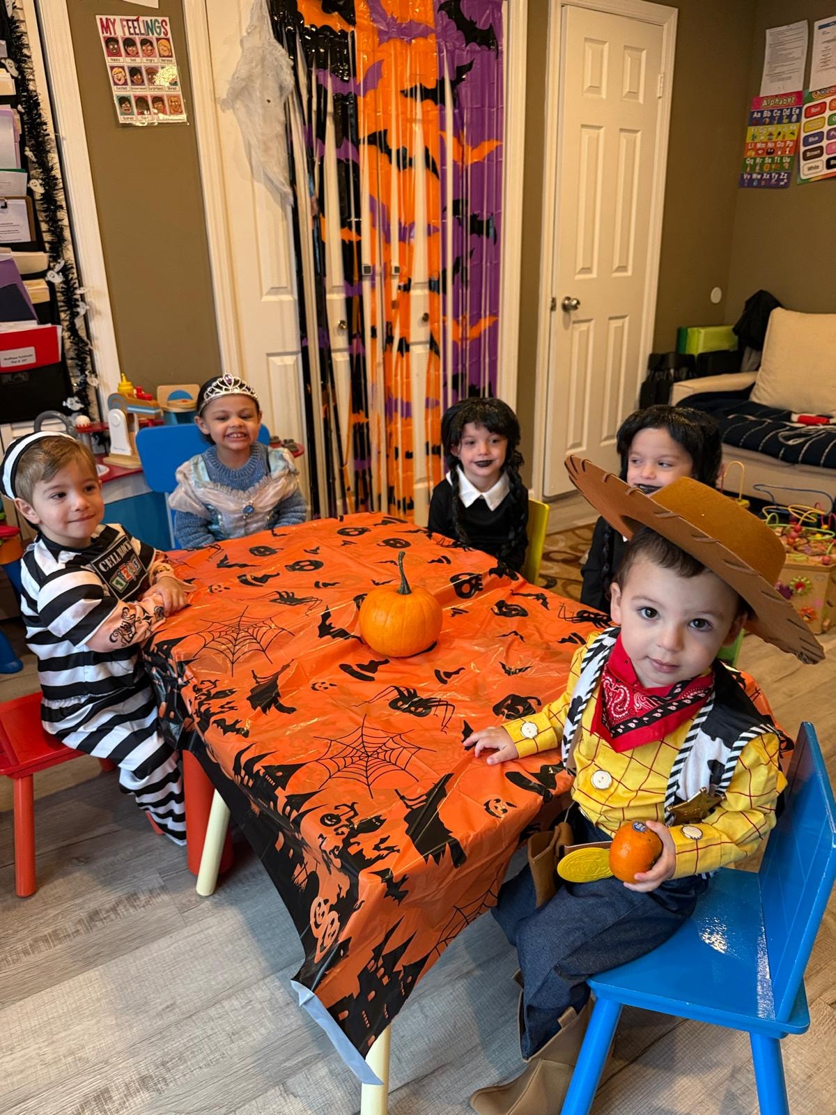 Children and teacher dressed in Halloween costumes celebrating together